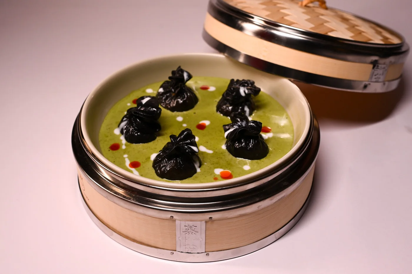 Charcoal cheese dimsums in Thai green curry